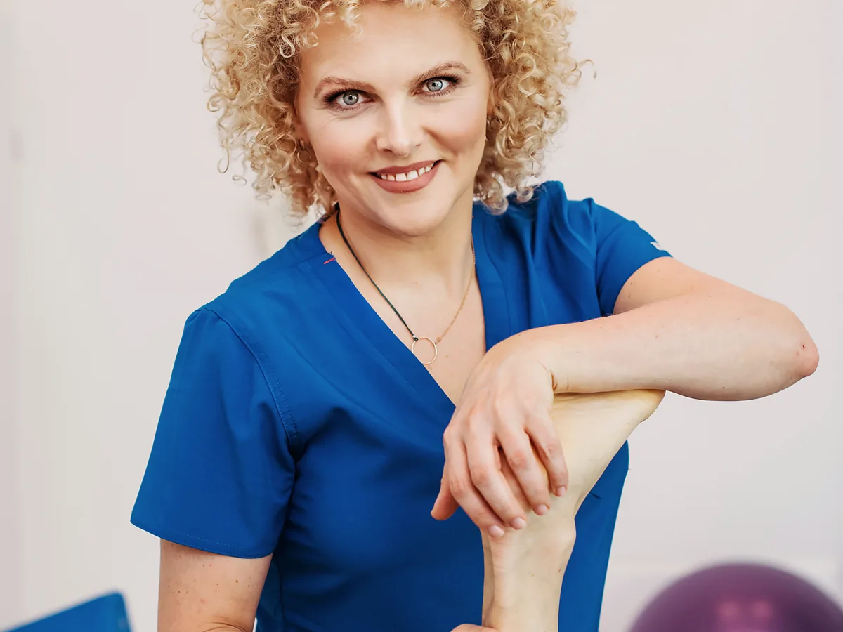 dr n. med. Joanna Stodolna-Tukendorf unosi wyprostowaną nogę pacjentki, trzymając jej piętę